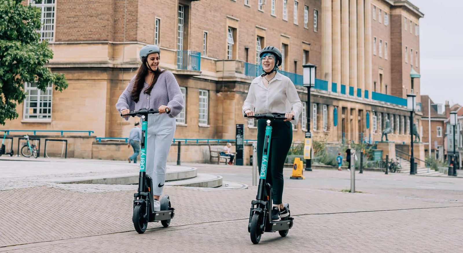 women riding Beryl e-scooters